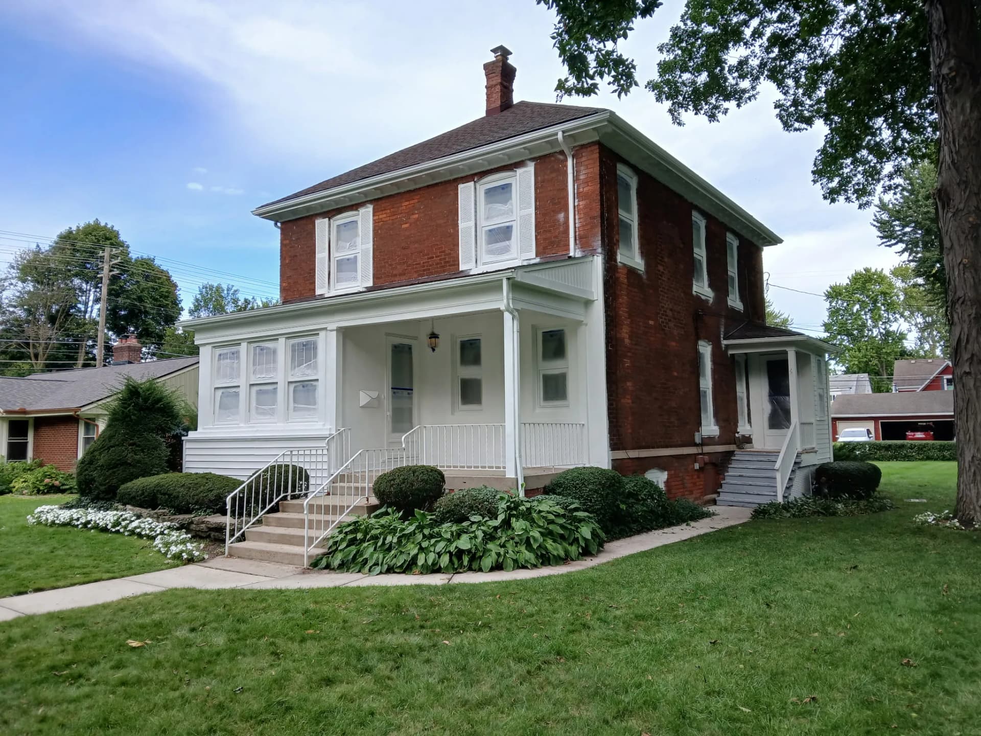 Painted Brick Exterior Before and After on a Classic Two-Story Home image
